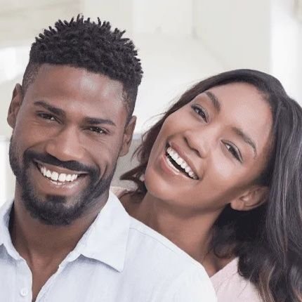 younger couple hugging inside | dentist dedham ma